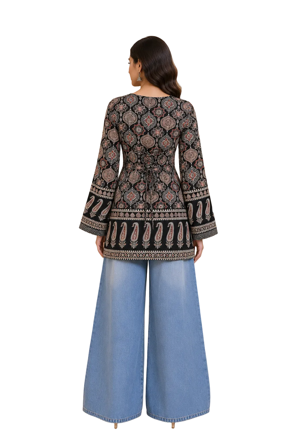 A woman stands with her back to the camera wearing a black embroidered long-sleeve kurta with intricate multicolor patterns and wide-leg light blue denim pants in a warm beige interior setting.